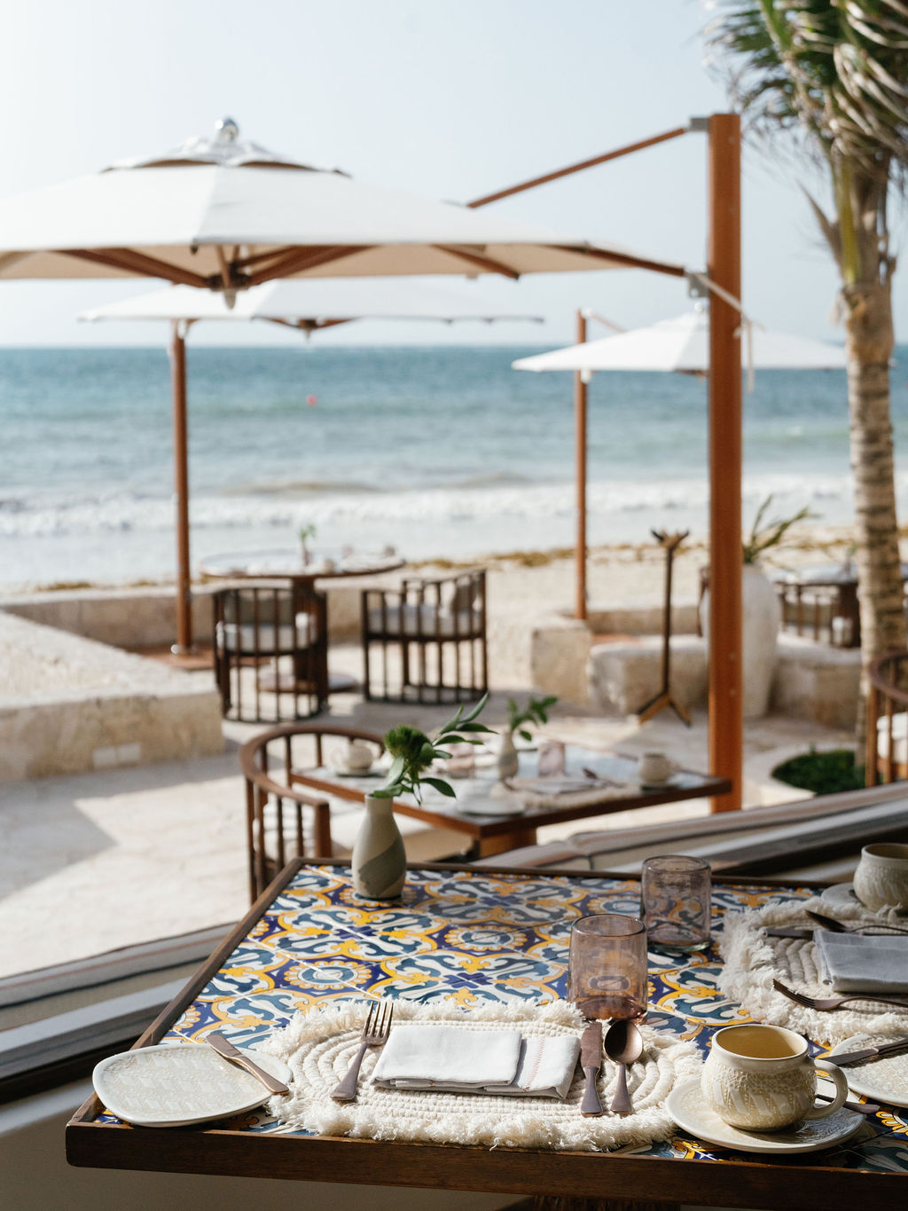 Patio at Belmond Maroma with umbrellas and tile tables